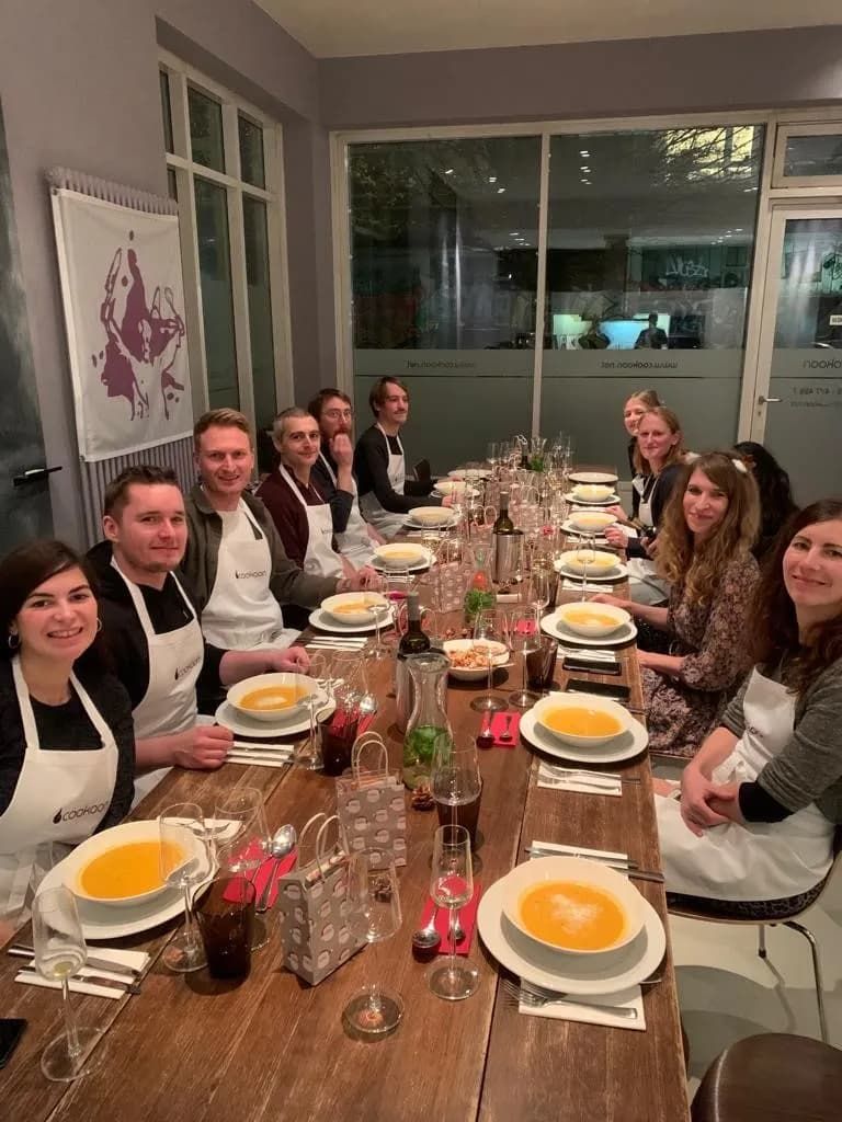 Die artaxo-Weihnachtsfeier 2022. Die Kolleg:innen sitzen sich jeweils gegenüber an einer langen Tafel und haben eine Suppe vor sich auf dem Teller.